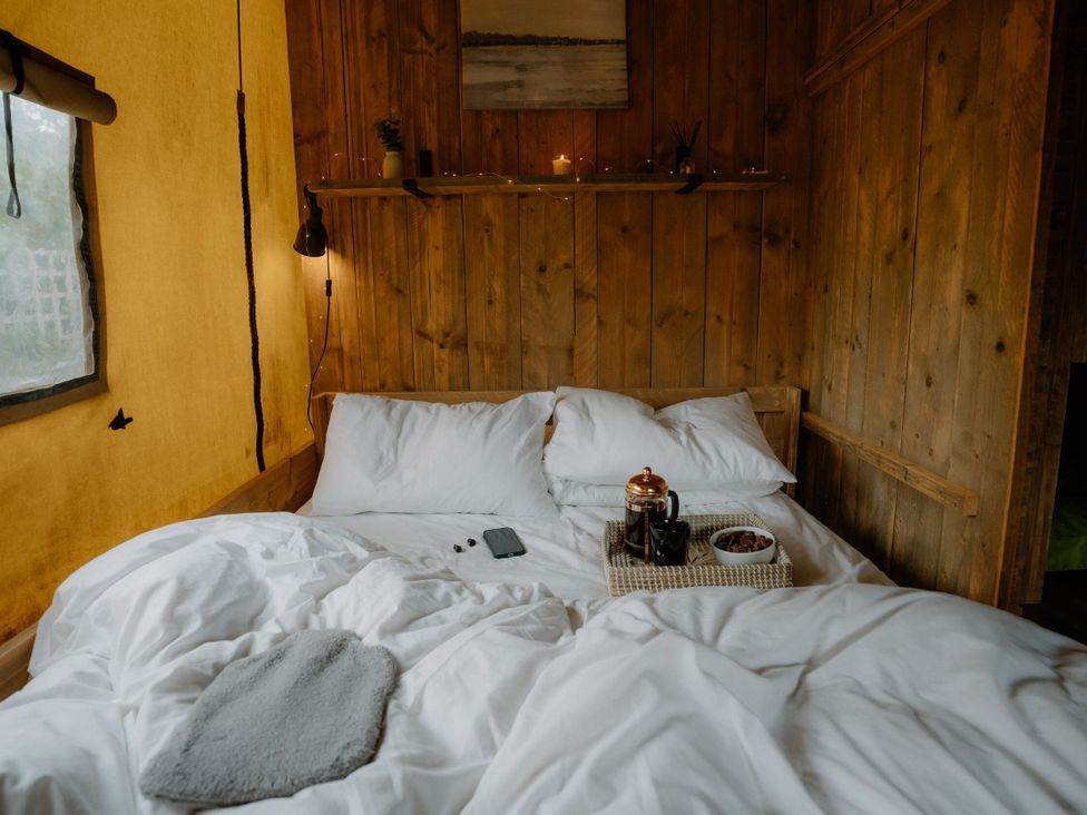 A bedroom with a bed and coffee tray at Standard Safari Tent in Fair Oak