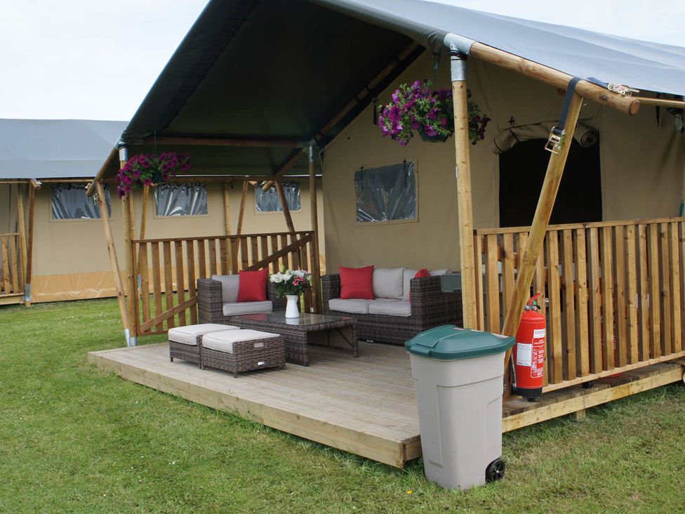 A patio with outdoor seating and a coffee table at Standard Safari Tent in Fair Oak