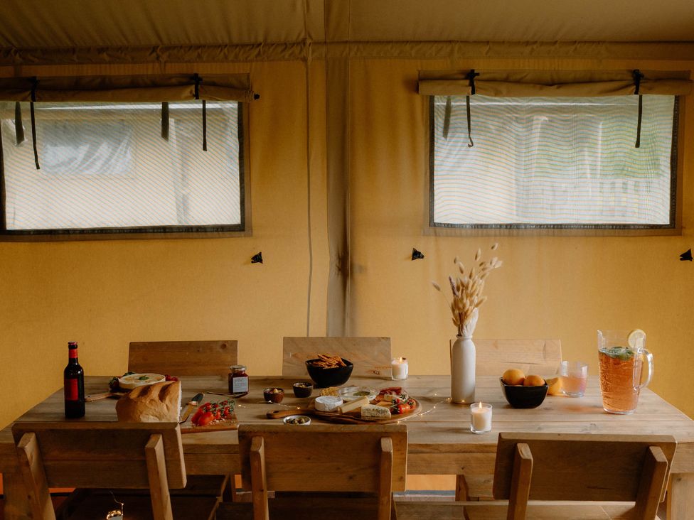 A dining room with a table set with food at Standard Safari Tent in Fair Oak