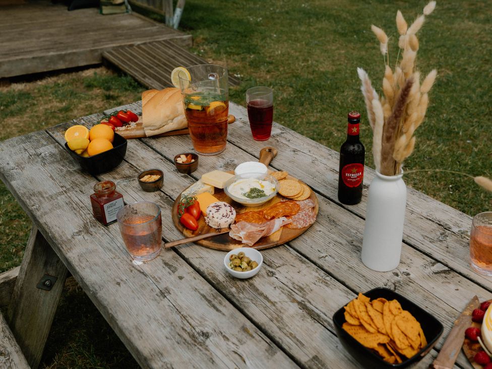 A wooden table with food and drinks at Standard Safari Tent Fair Oak