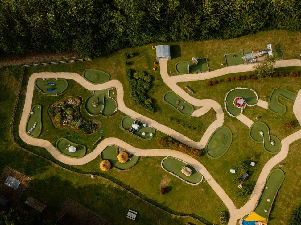 A mini golf course with paths and greenery at Deluxe Safari Tent in Fair Oak