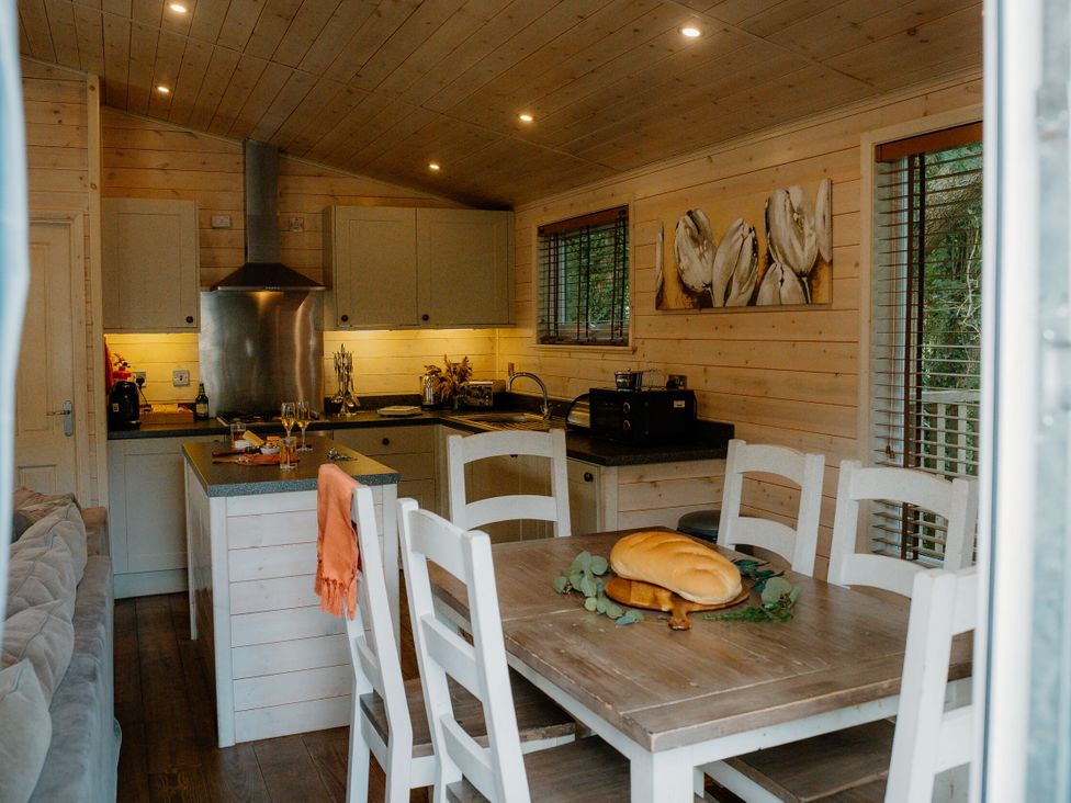 A kitchen with dining table and chairs at Spitfire Lodge in Fair Oak