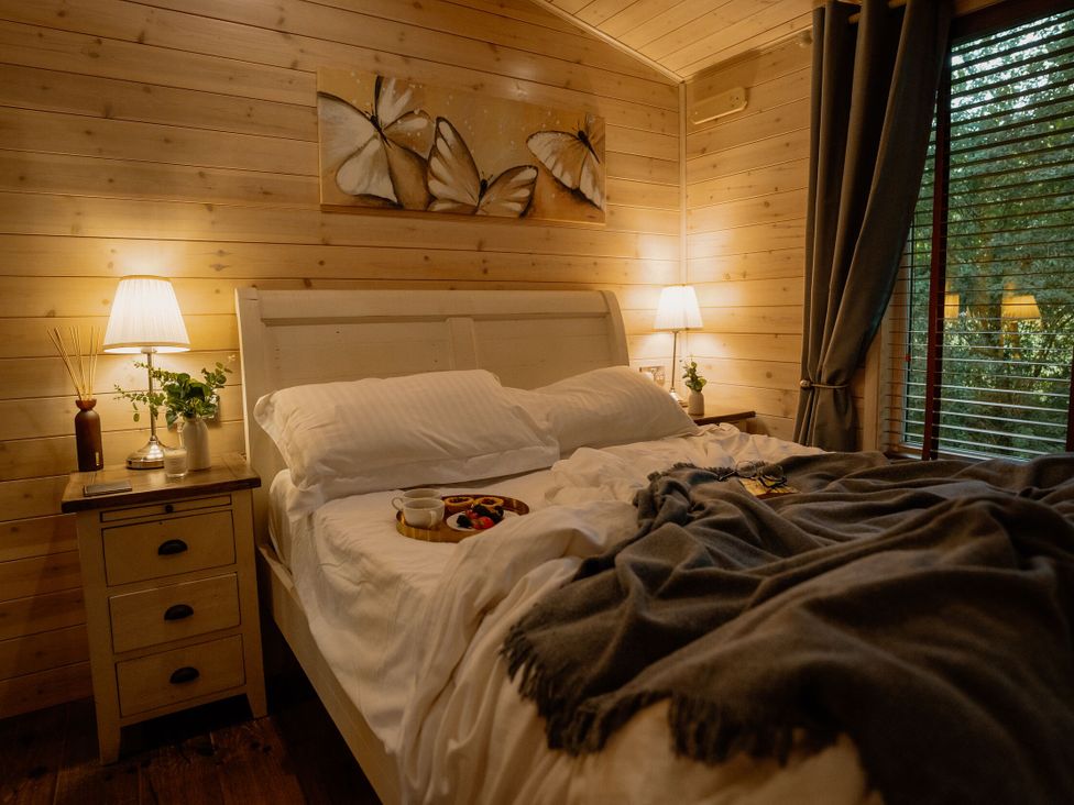 A bedroom with a bed and bedside table at Spitfire Lodge in Fair Oak
