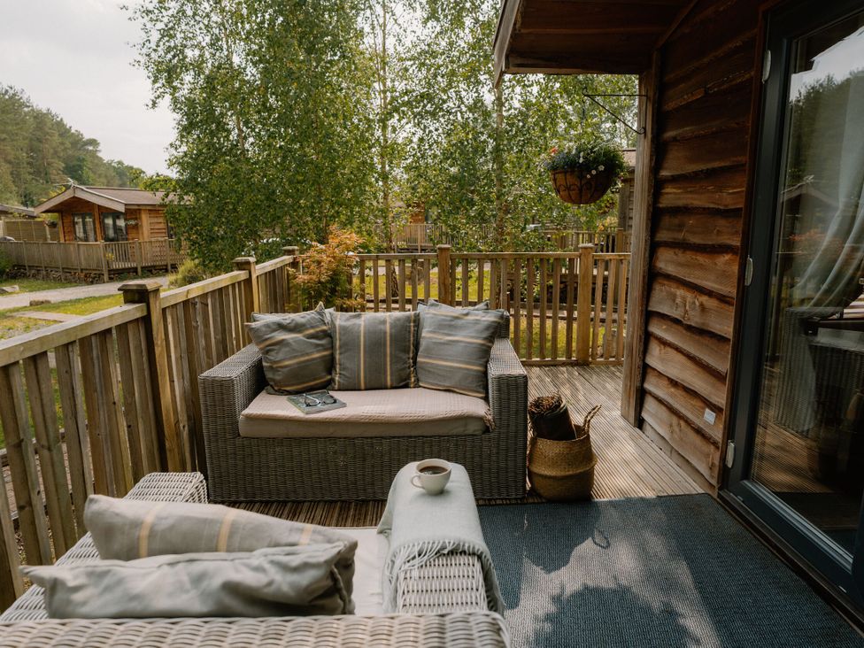 An outdoor seating area with a sofa and cushions at Spitfire Lodge in Fair Oak