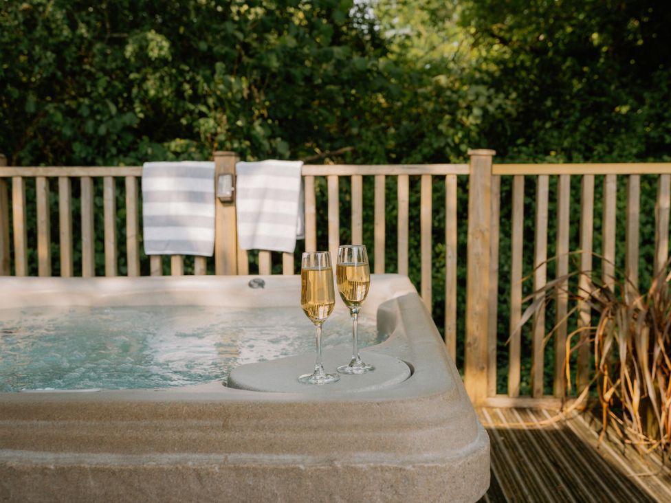 A hot tub with two glasses on the edge at Spitfire Lodge in Fair Oak
