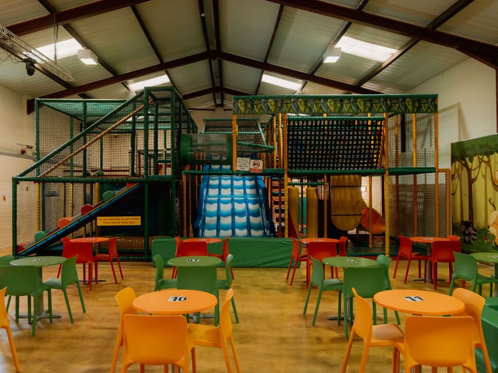 An indoor play area with a climbing frame and slide at Spitfire Lodge in Fair Oak
