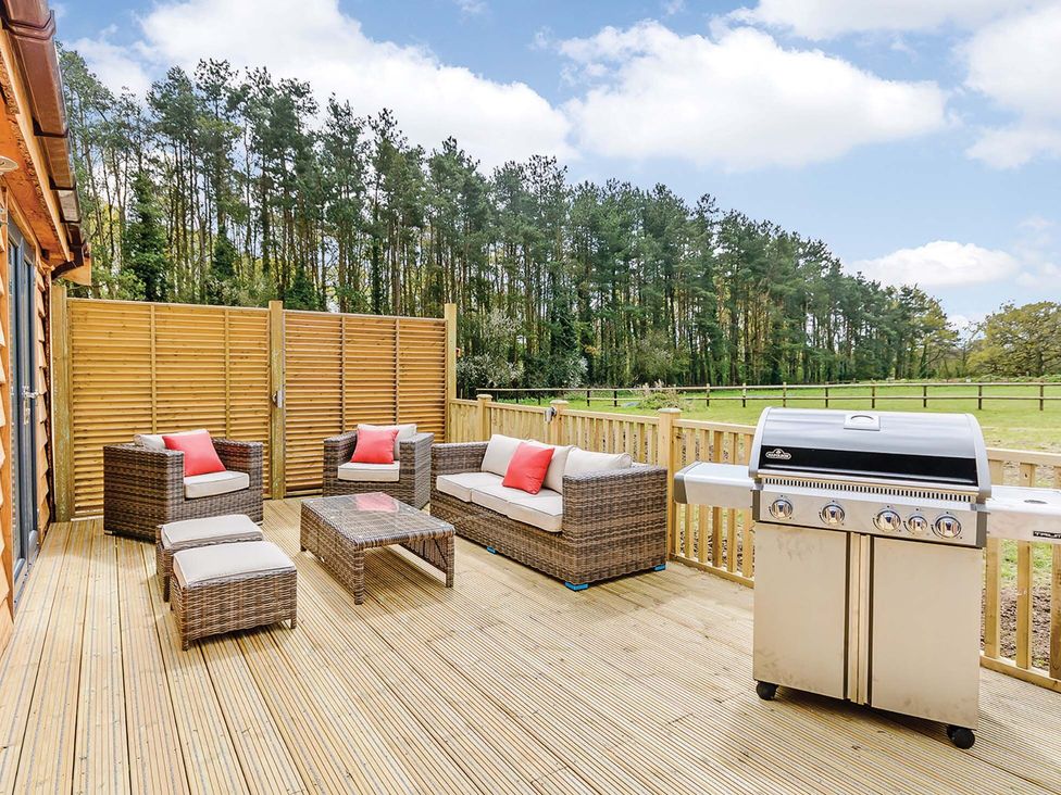 An outdoor seating area with furniture and a barbecue grill at Lancaster Lodge Fair Oak