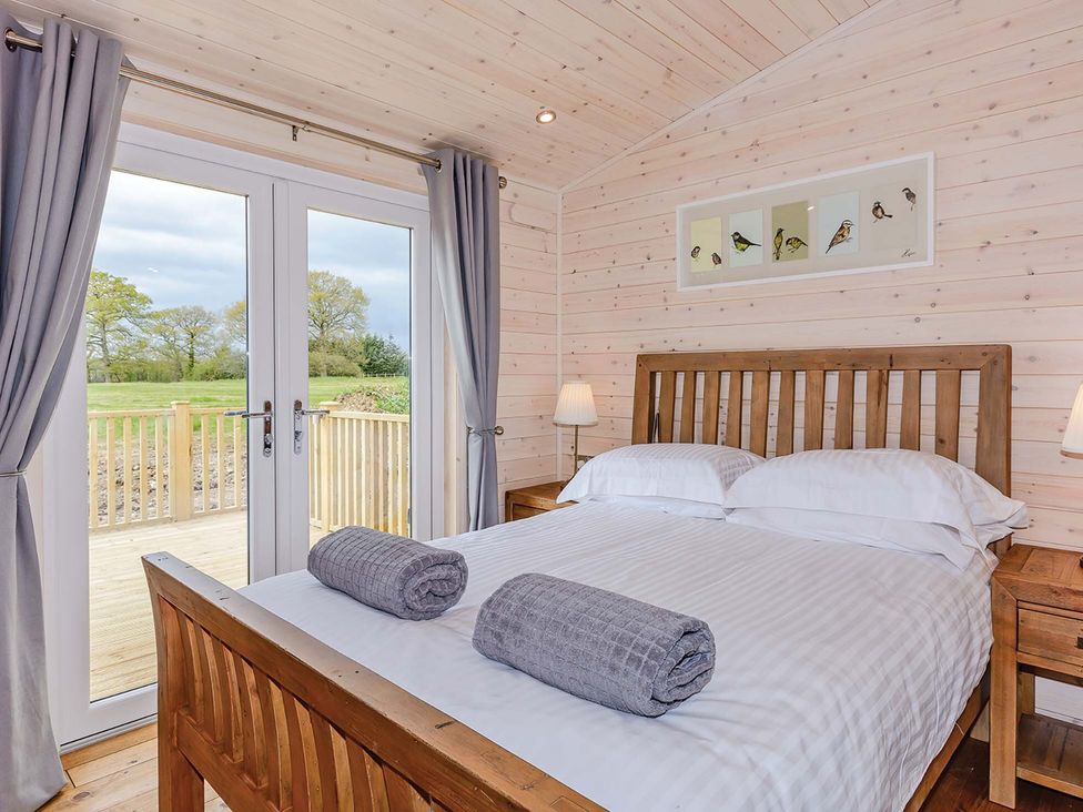 A bedroom with a double bed and sliding doors at Lancaster Lodge in Fair Oak