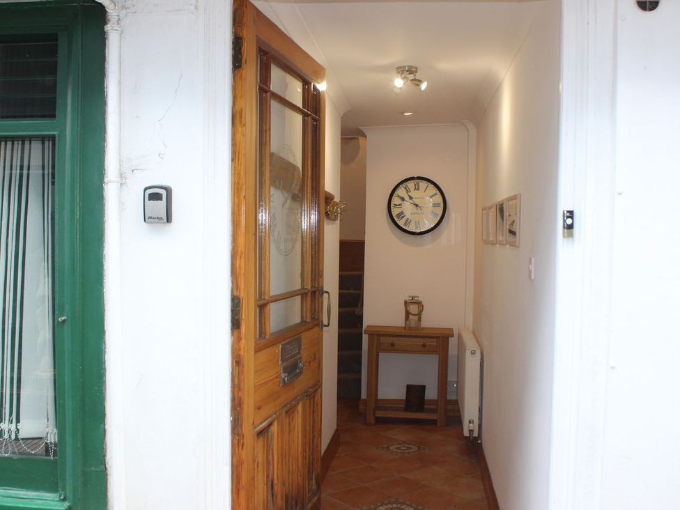 A hallway with a clock and a table at The Little Clock House in Dartmouth