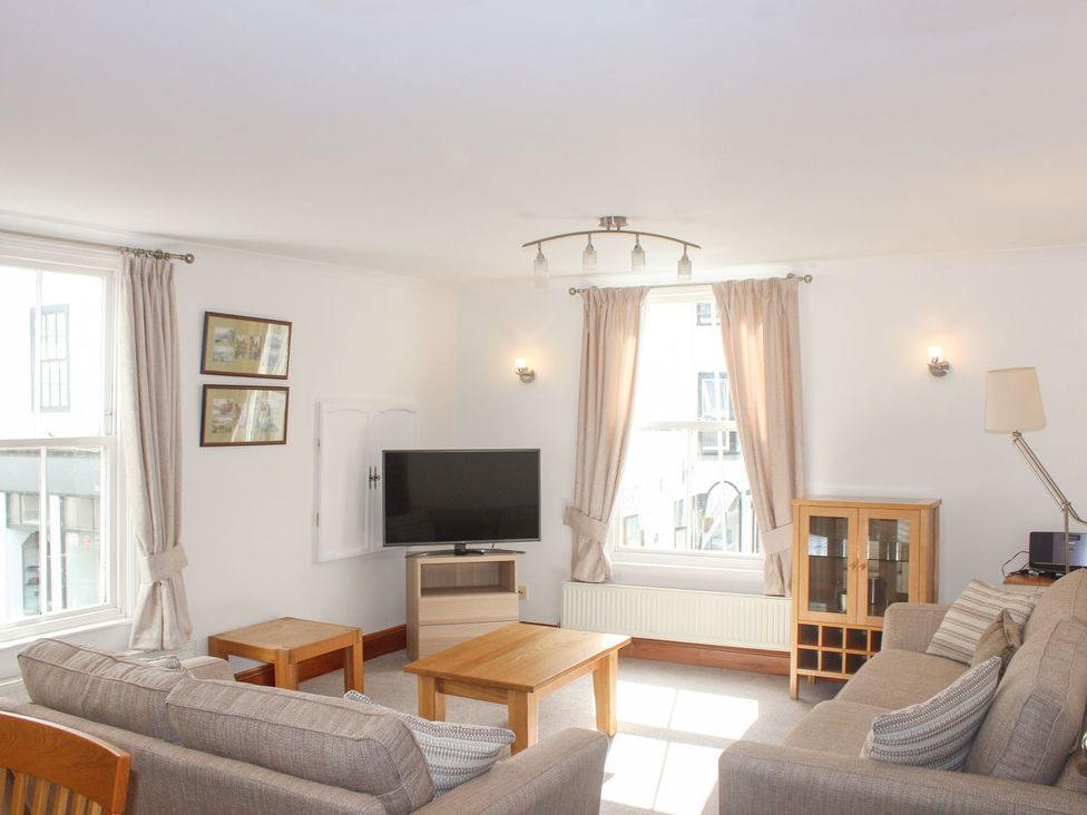 A living room with a television and sofa at The Little Clock House in Dartmouth