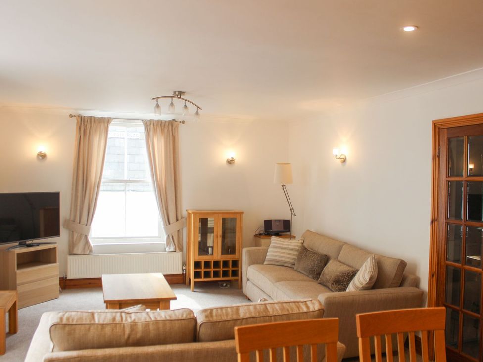 A living room with a sofa and television at The Little Clock House in Dartmouth