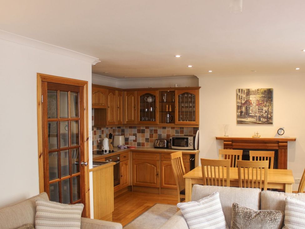 A kitchen with a dining table and chairs at The Little Clock House in Dartmouth