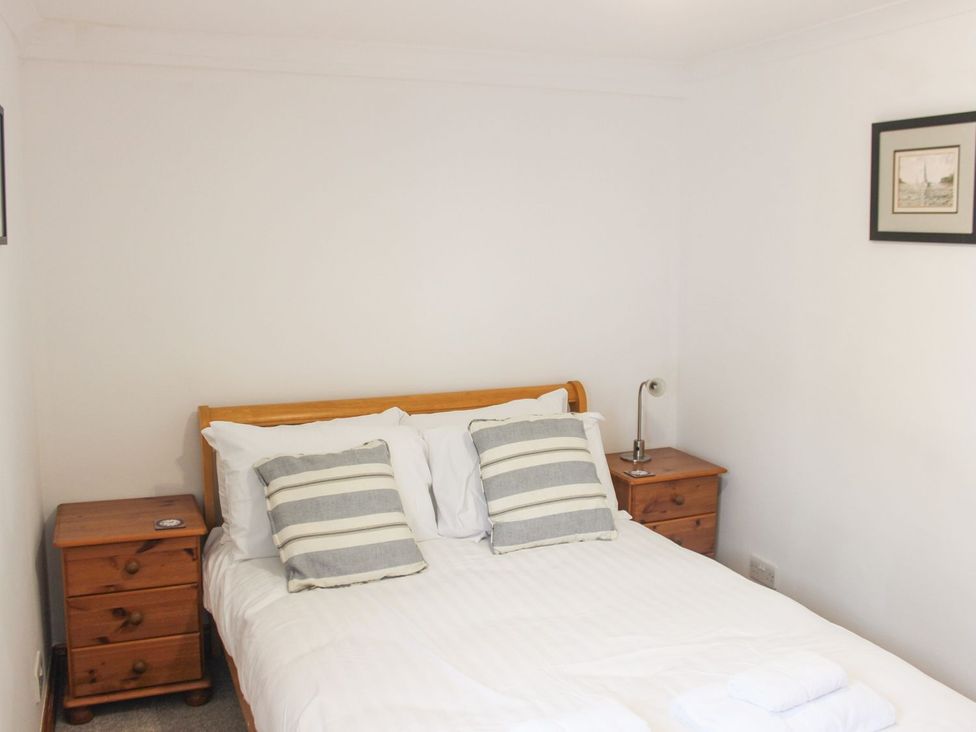 A bedroom with a bed and bedside tables at The Little Clock House in Dartmouth
