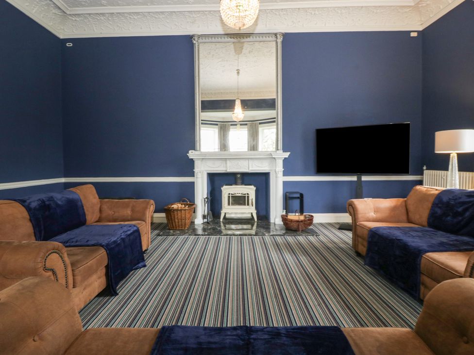 A living room with a fireplace and TV at Frenchay Park House in Bristol