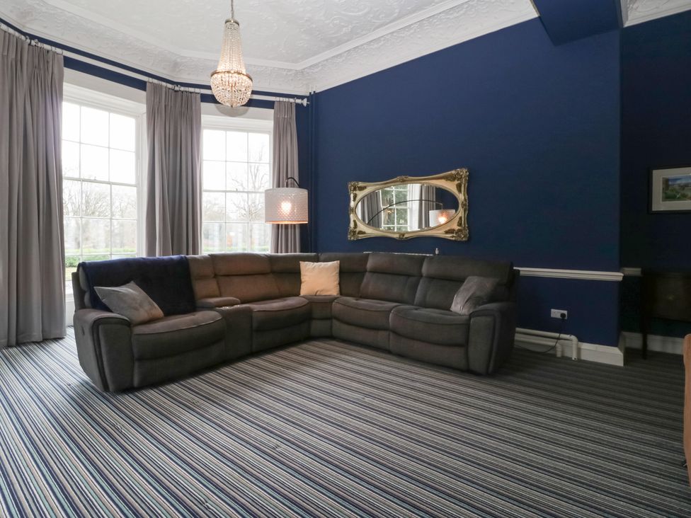 A living room with a sectional sofa and window at Frenchay Park House in Bristol