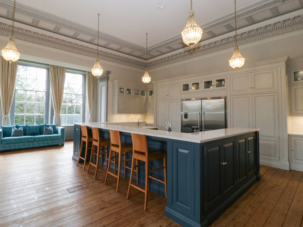 A kitchen with a large island and stools at Frenchay Park House in Bristol