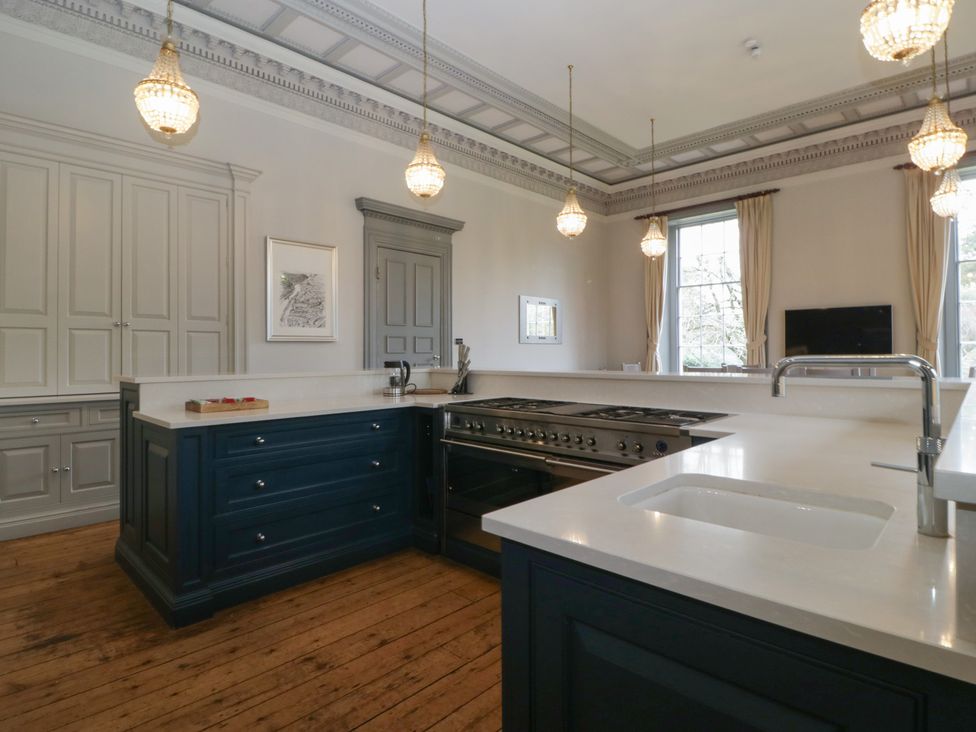 A kitchen with a central island and built-in appliances at Frenchay Park House in Bristol