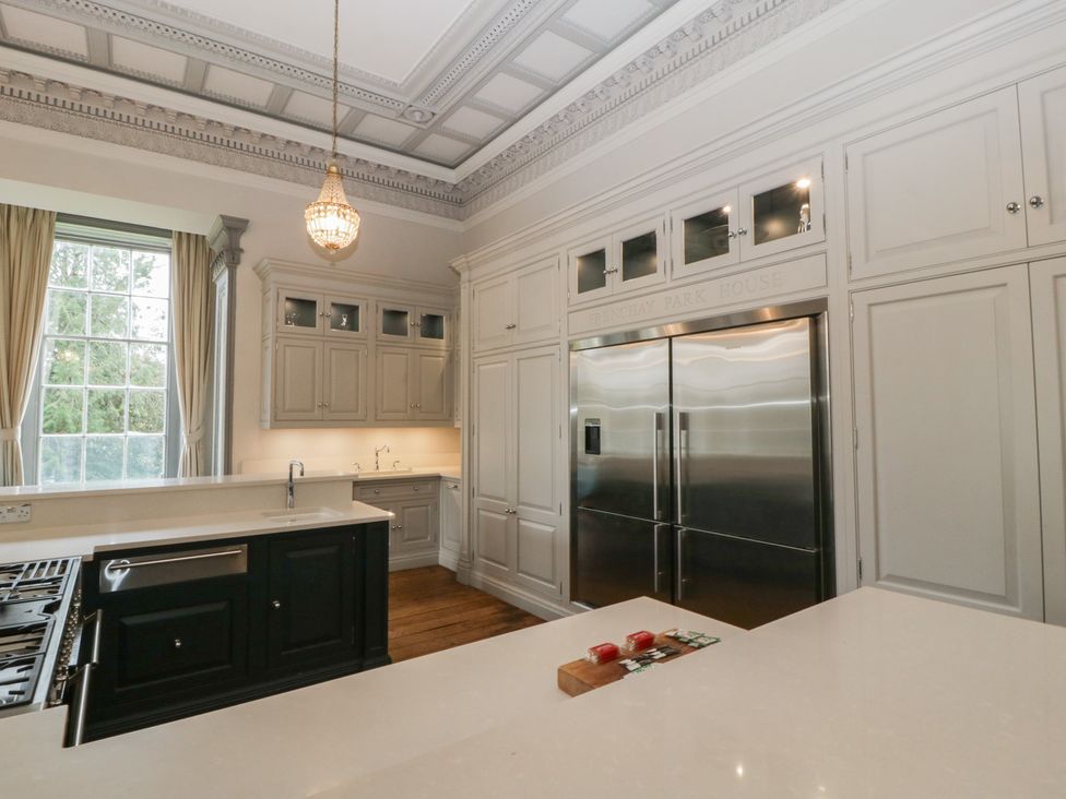 A kitchen with cabinets and a refrigerator at Frenchay Park House in Bristol