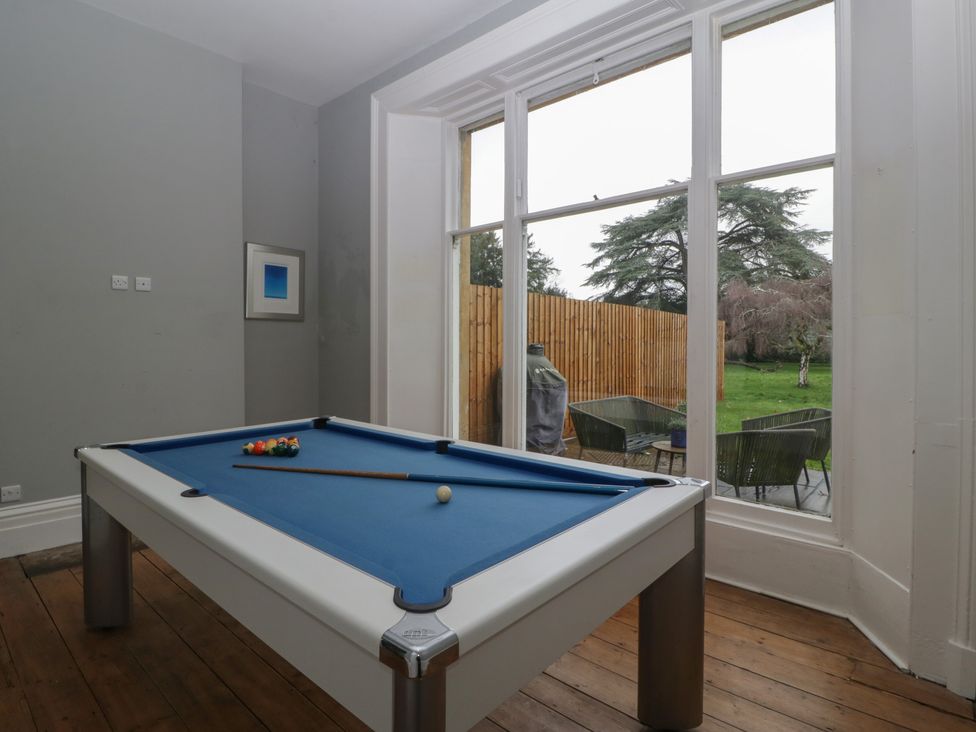A game room with a pool table looking out to the garden at Frenchay Park House in Bristol