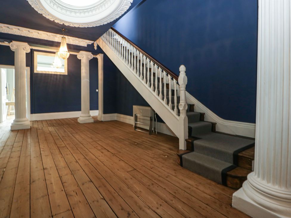 An entrance hall with a staircase and columns at Frenchay Park House in Bristol