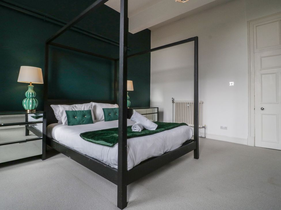 A bedroom with a four-poster bed and modern furniture at Frenchay Park House in Bristol