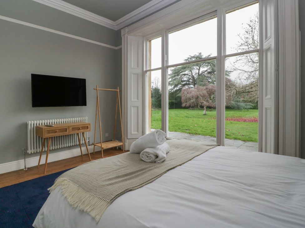 A bedroom with a bed and view of the garden at Frenchay Park House in Bristol