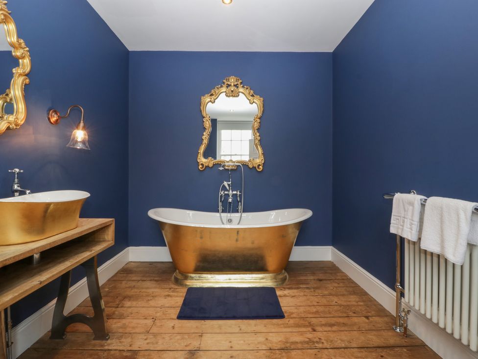 A bathroom with a freestanding tub and wooden vanity at Frenchay Park House Bristol