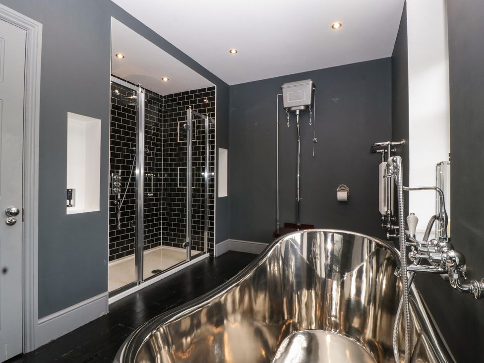 A bathroom featuring a bathtub and shower at Frenchay Park House in Bristol