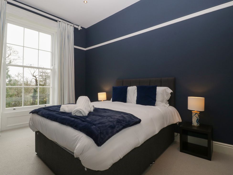 A bedroom with a bed and a nightstand at Frenchay Park House in Bristol
