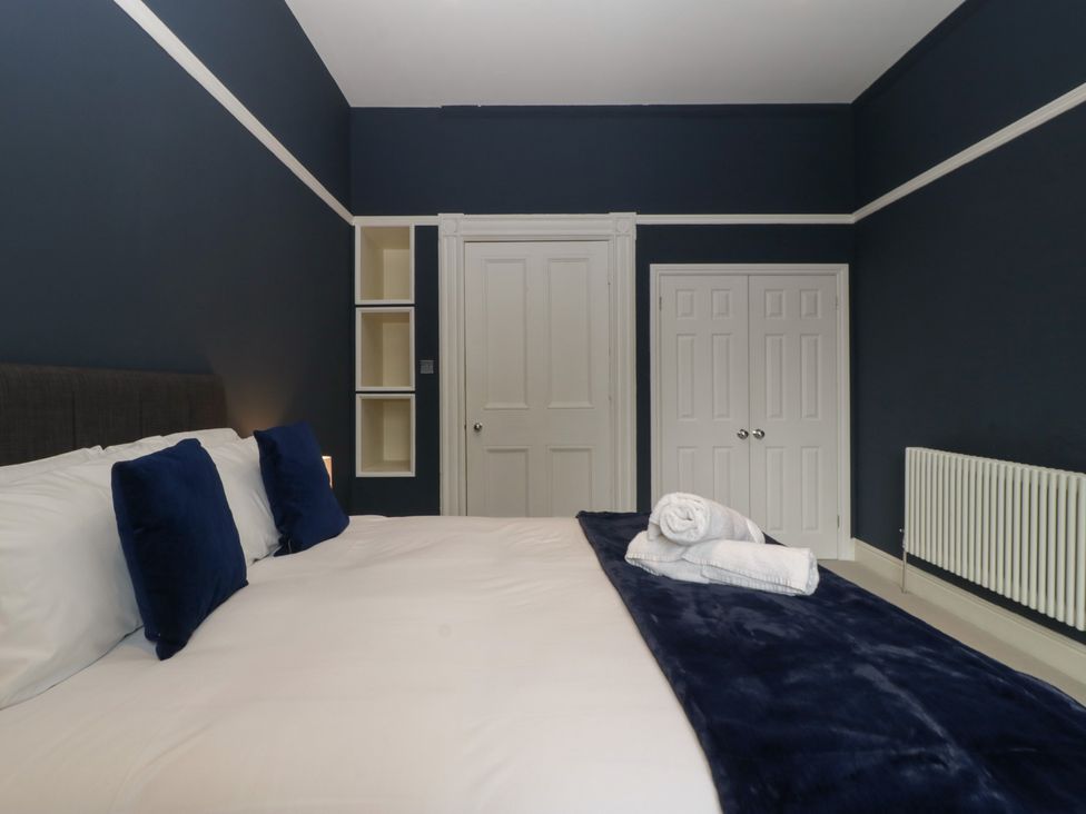 A bedroom with a bed and shelves at Frenchay Park House in Bristol