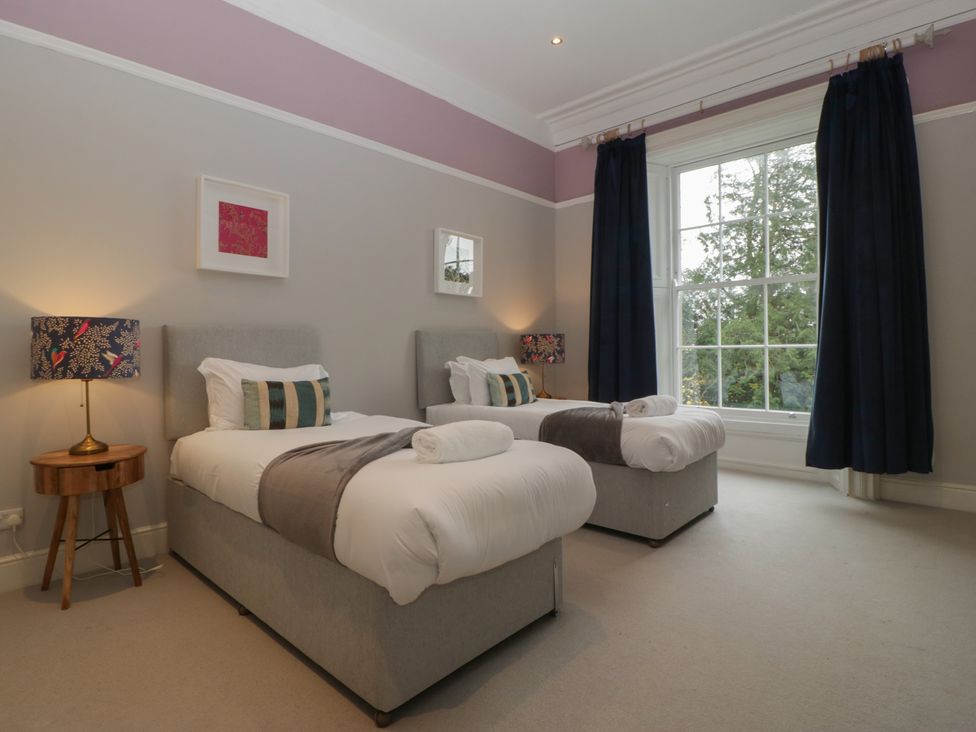A bedroom with two beds and a bedside table at Frenchay Park House in Bristol