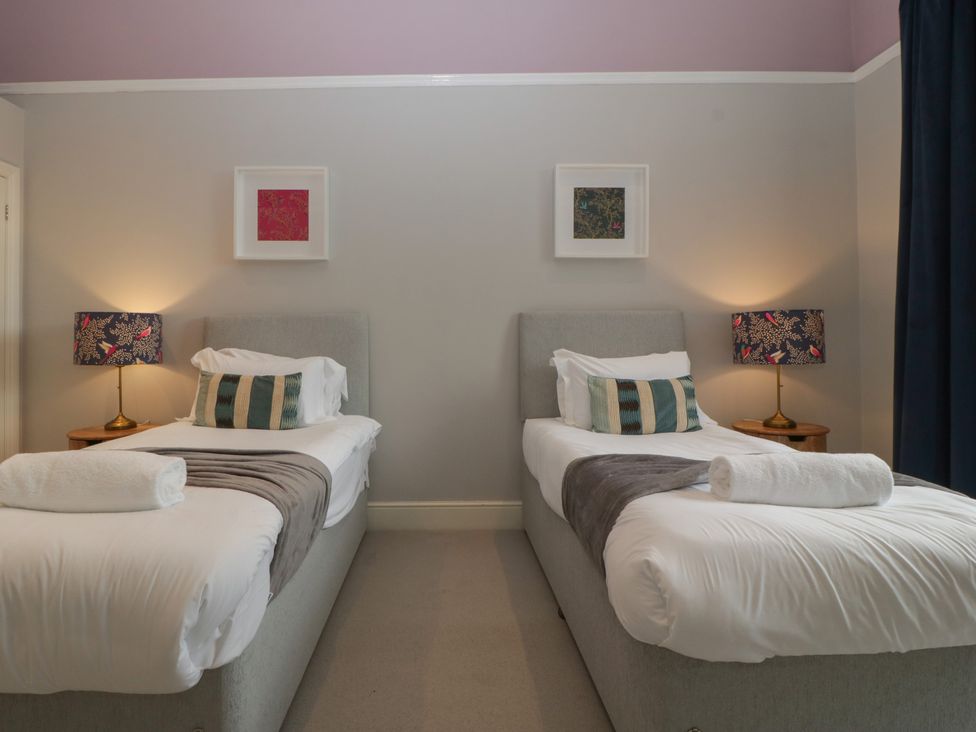 A bedroom with two single beds and bedside lamps at Frenchay Park House in Bristol