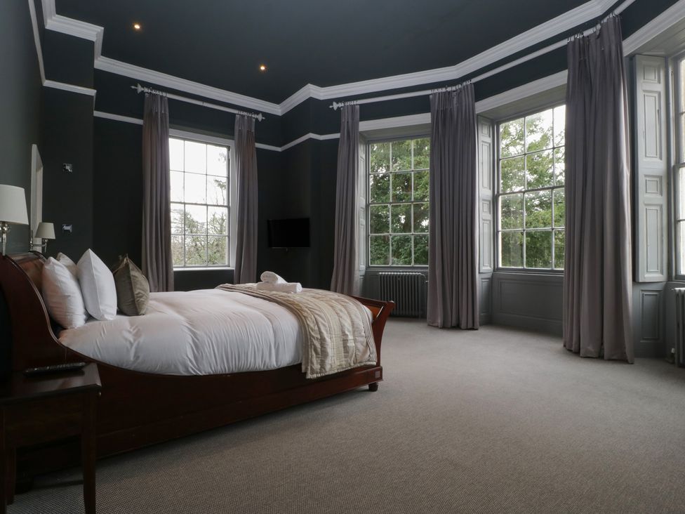 A bedroom with a bed and windows at Frenchay Park House in Bristol