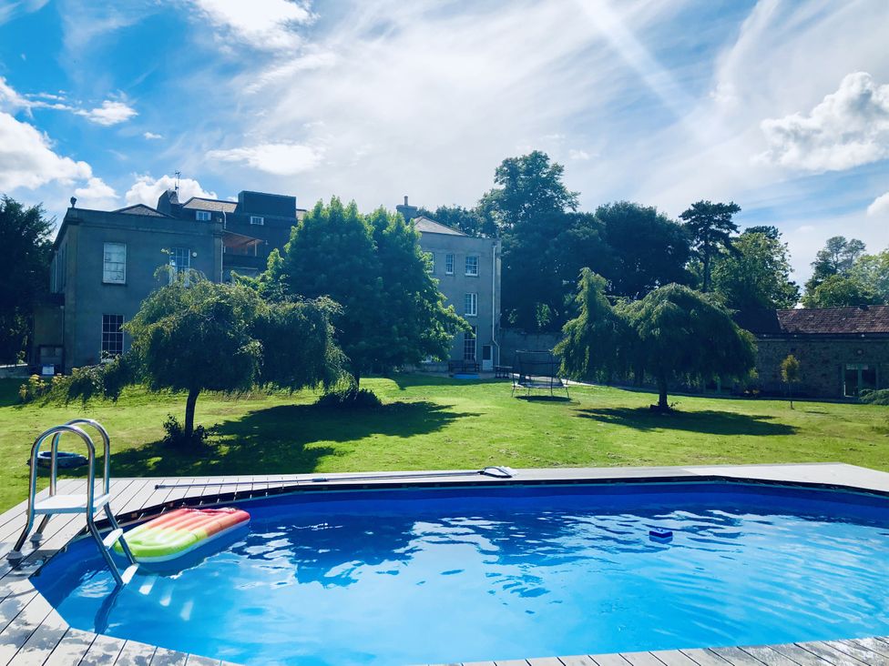 A swimming pool with a ladder and lawn at Frenchay Park House in Bristol