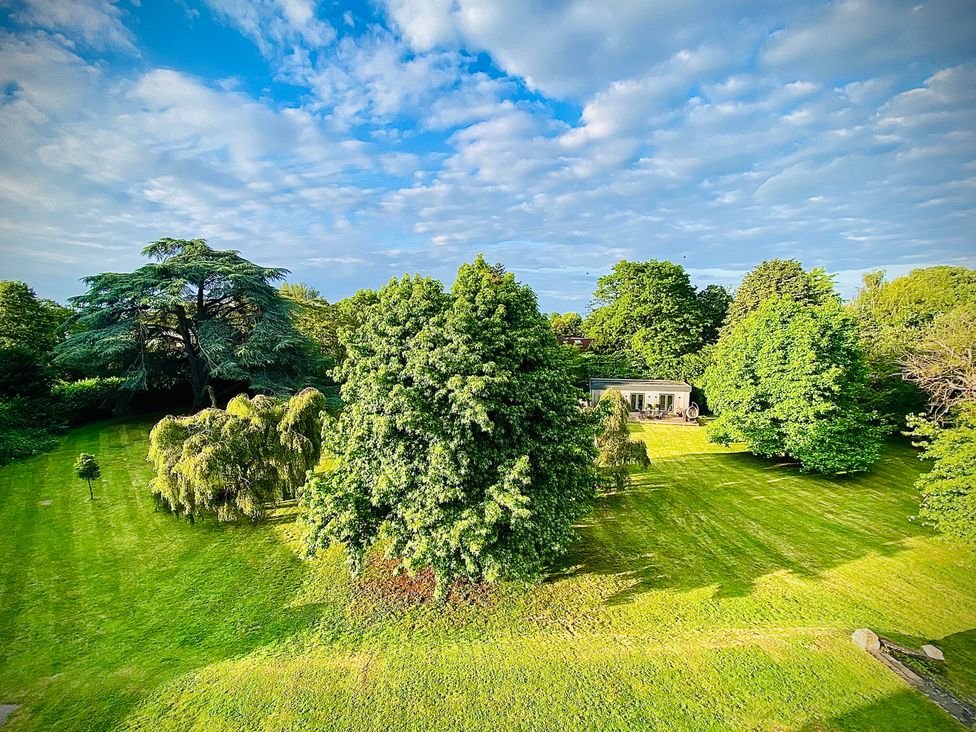 A garden with trees and a house at Frenchay Park House in Bristol