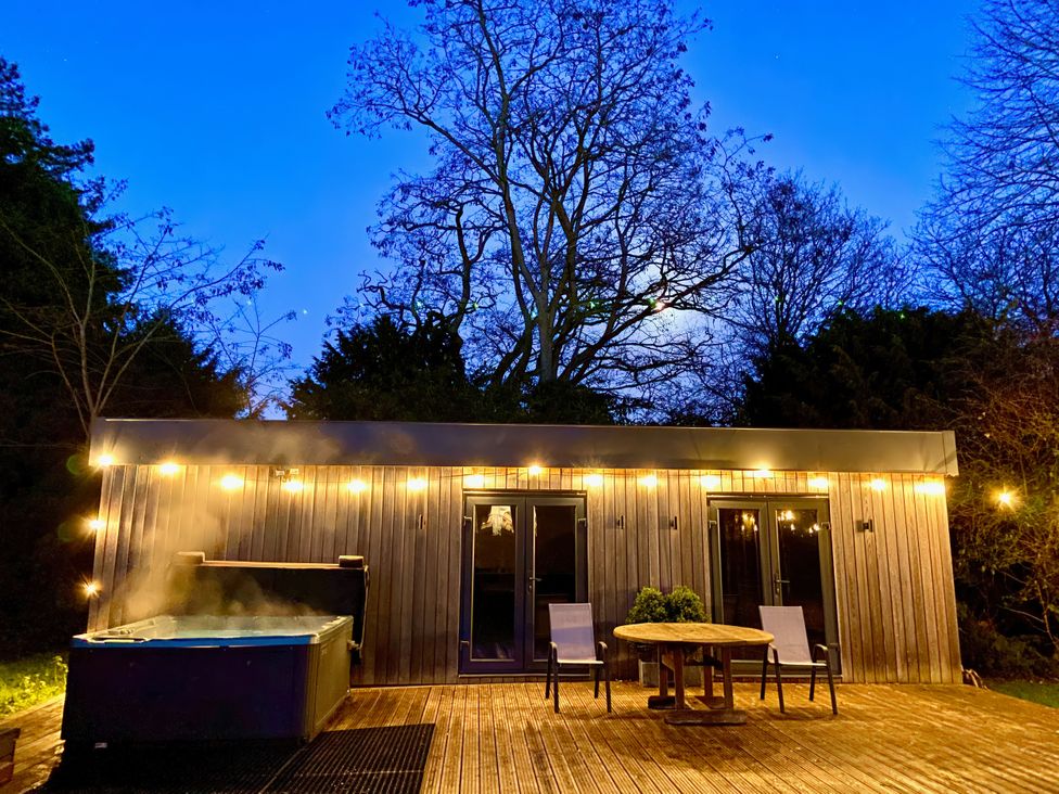 An outdoor area with a hot tub and seating at Frenchay Park House in Bristol