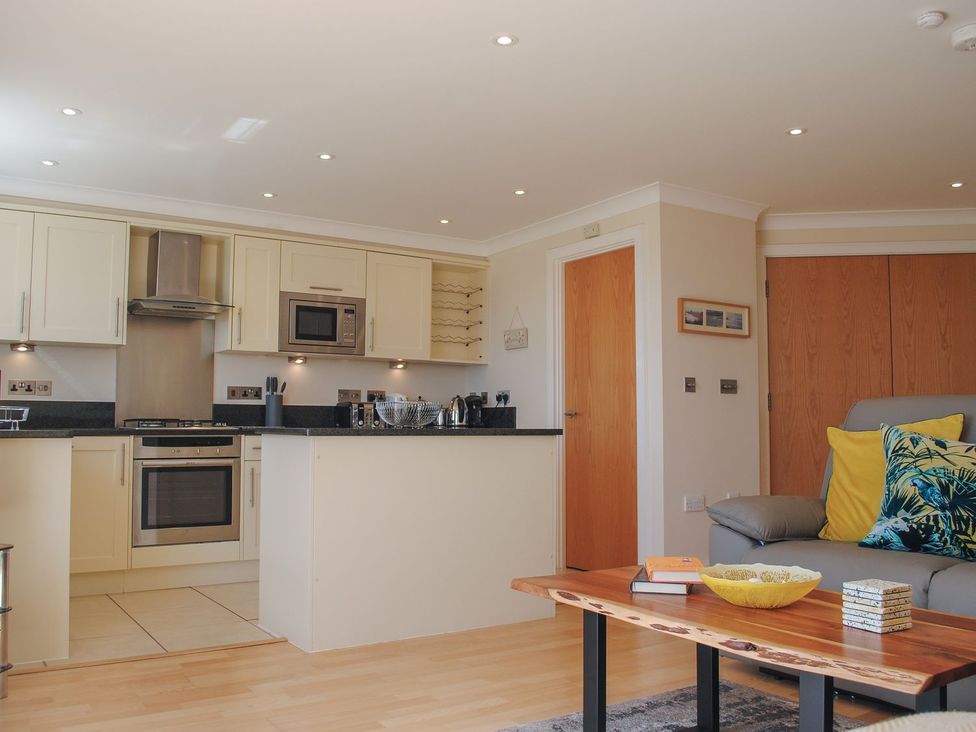 A kitchen and living room area with appliances and seating at 8 Thurlestone Beach in Kingsbridge