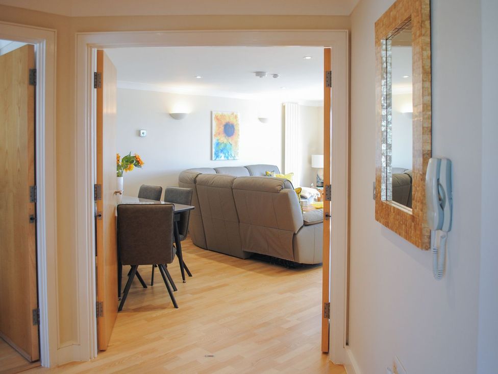 A living room with a sofa and dining area at 8 Thurlestone Beach in Kingsbridge