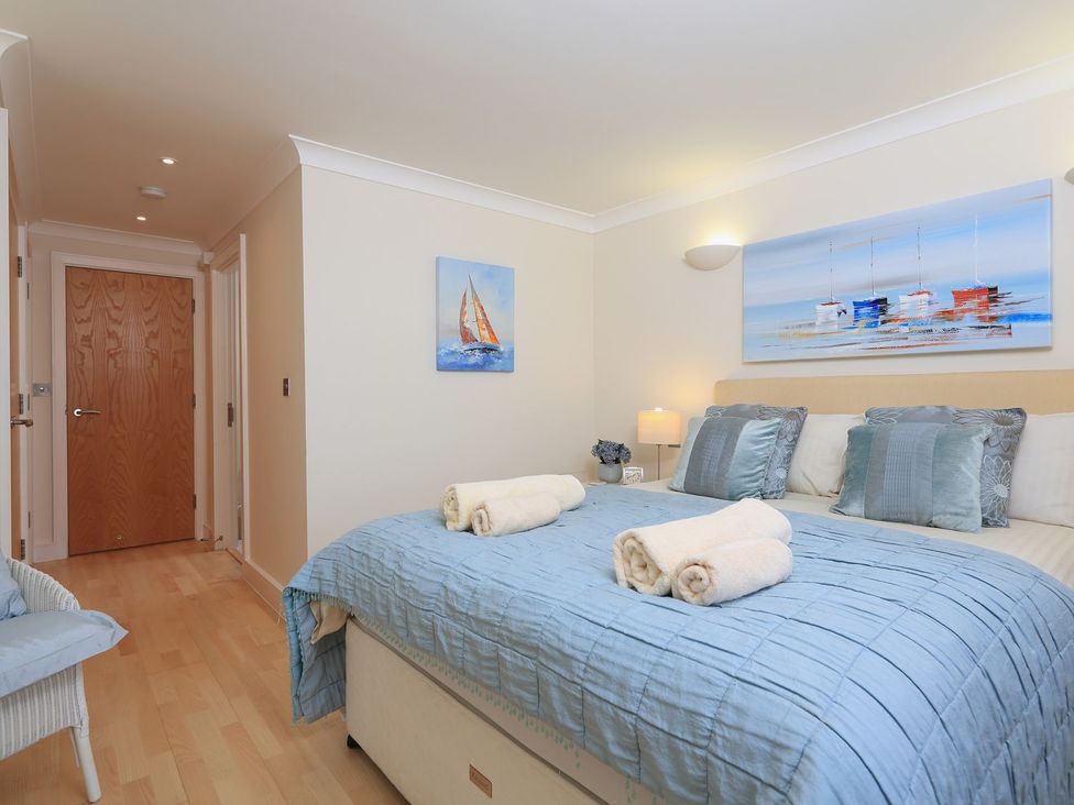 A bedroom with a bed and artwork at 8 Thurlestone Beach in Kingsbridge