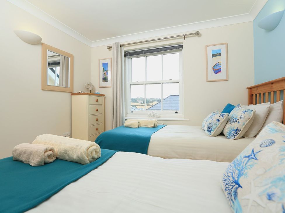 A bedroom with two beds and a window at 8 Thurlestone Beach in Kingsbridge