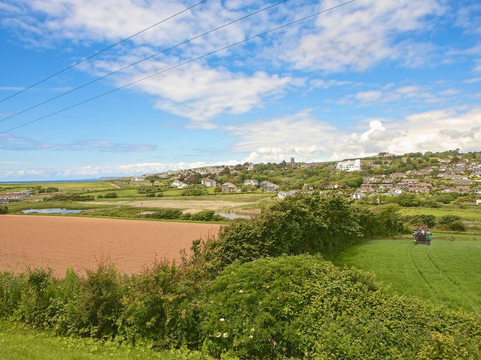 A landscape view of fields, a lake, and houses at 8 Thurlestone Beach in Kingsbridge