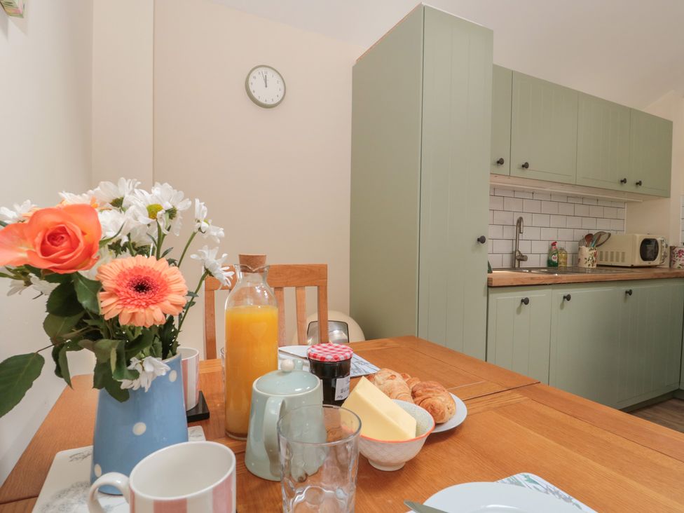 A kitchen with a table set for breakfast at Wheelwright Cottage, Moreton-In-Marsh