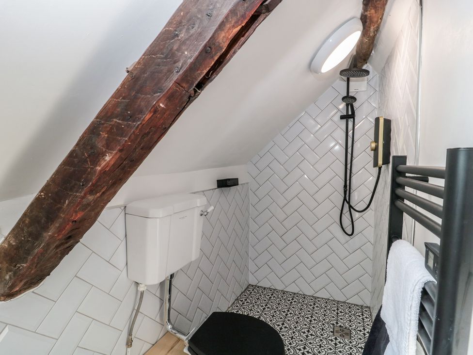 A bathroom with a toilet and shower at Wheelwright Cottage in Moreton-In-Marsh