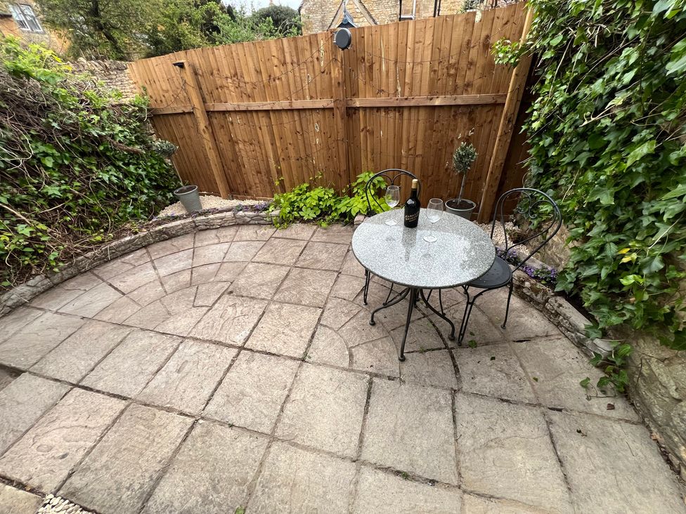 A garden with a table and chairs in Wheelwright Cottage Moreton-In-Marsh