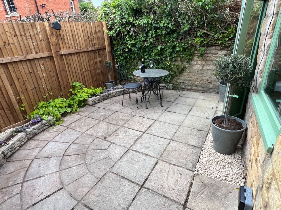 A garden with a table and chairs at Wheelwright Cottage Moreton-In-Marsh