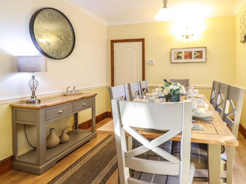 A dining room with a table set for dinner at Llwyn Derw Talybont