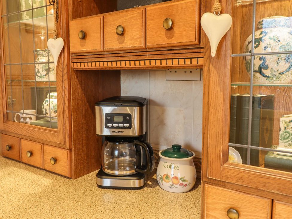 A kitchen with a coffee machine and a coffee canister at Llwyn Derw Talybont