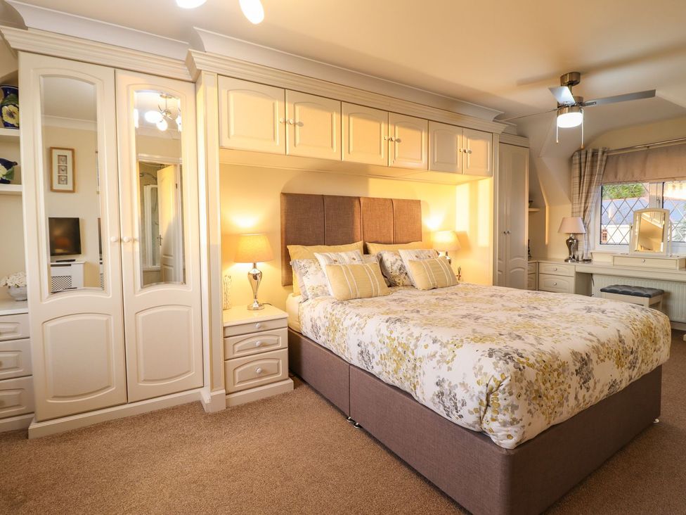 A bedroom with a bed and wardrobe at Llwyn Derw Talybont