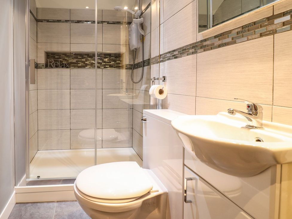 A bathroom with a toilet and sink next to a shower at Llwyn Derw in Talybont