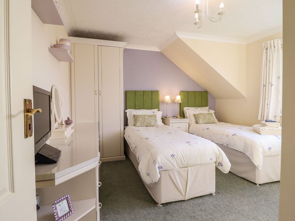 A bedroom with two beds and a television at Llwyn Derw Talybont